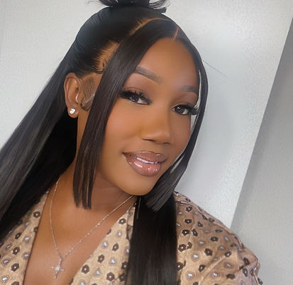 Smiling woman with long dark hair, half-up bun, bangs