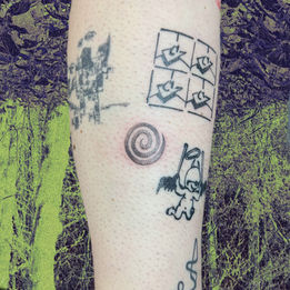 A fine-line tattoo of a stipply spiral on the back of the calf.