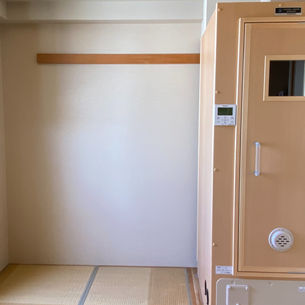 写真1：明石市マンションの和室に設置完了したコロナ社製ナノミストサウナ「ナノリッチ」一人用。畳の部屋に木製踏み台付きのベージュカラーの本体が収まっている