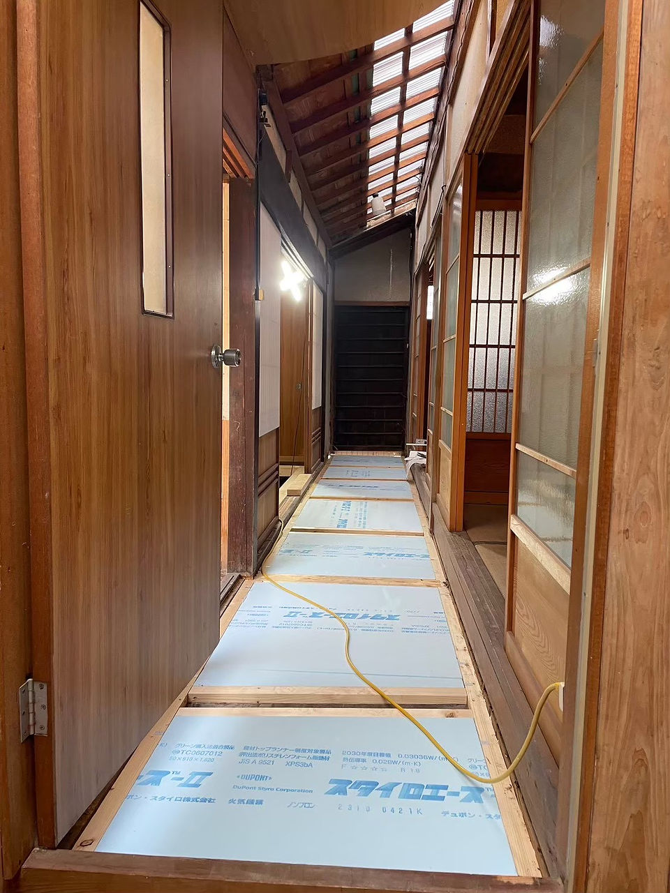 廊下の床下にスタイロエース（デュポン製）断熱材を根太間に施工した状態。天井も解体中