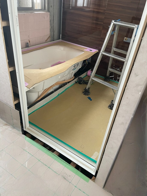 明石市の浴室リフォーム施工中写真。TOTOサザナの浴槽と壁パネルを設置中の状態。養生が施され、丁寧に組み上げられていく過程。