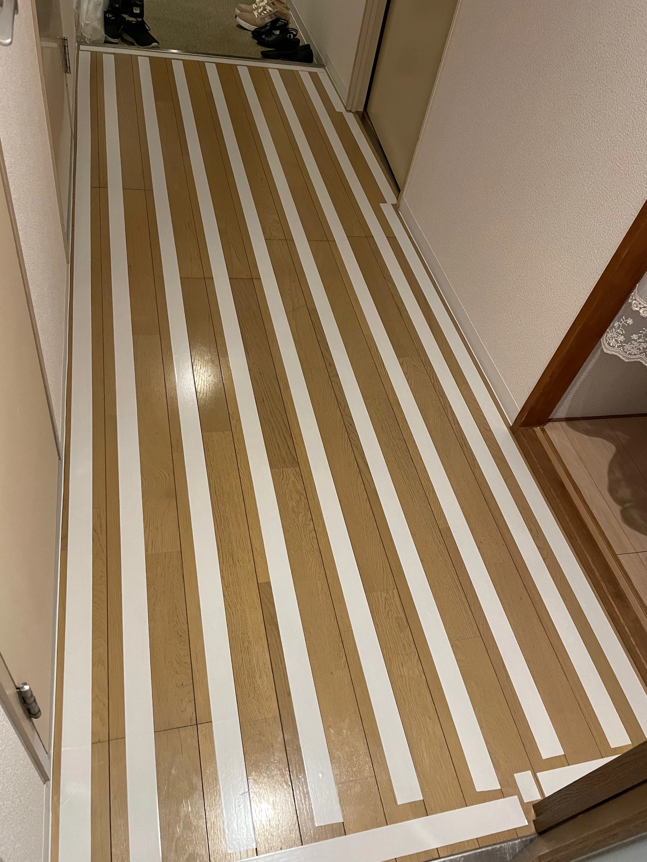 既存のフローリングに両面テープを貼っている