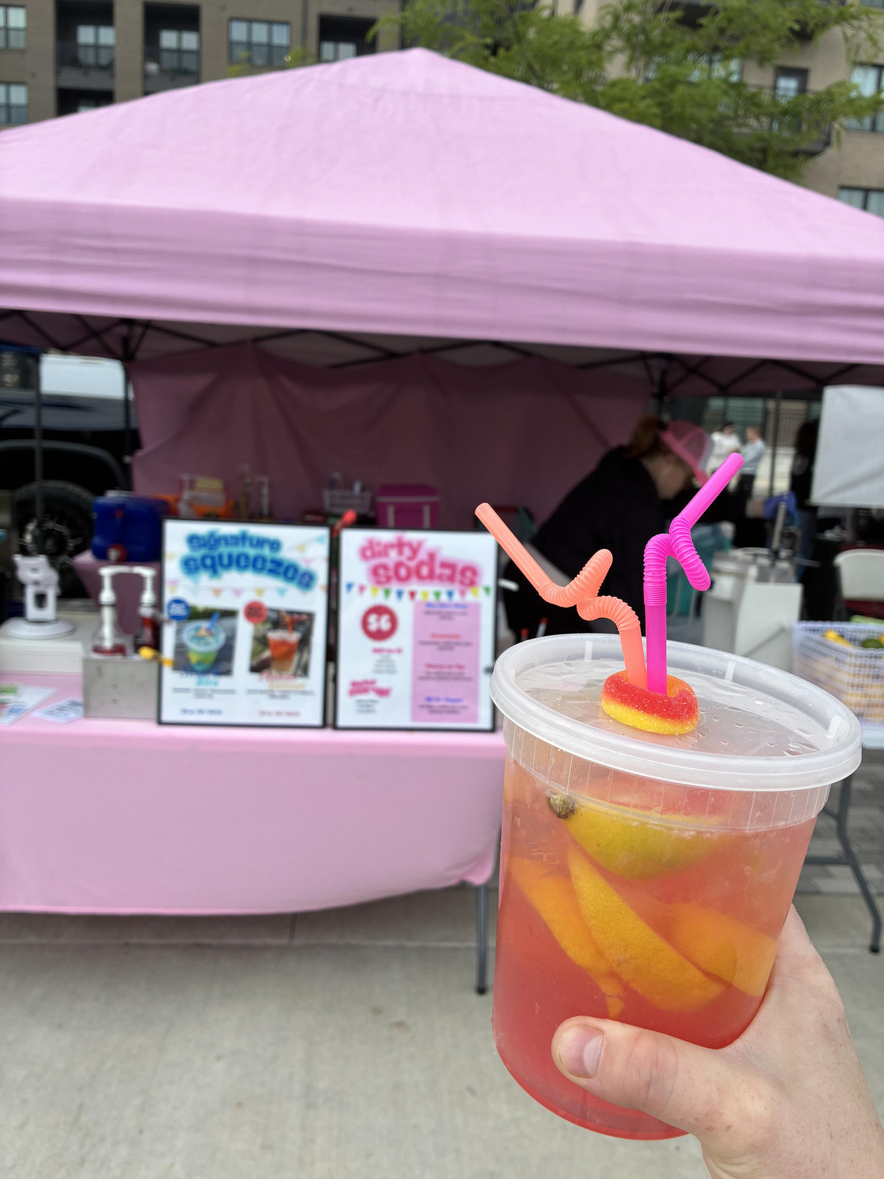 Fresh-squeezed lemonade held up in front of the pink tent