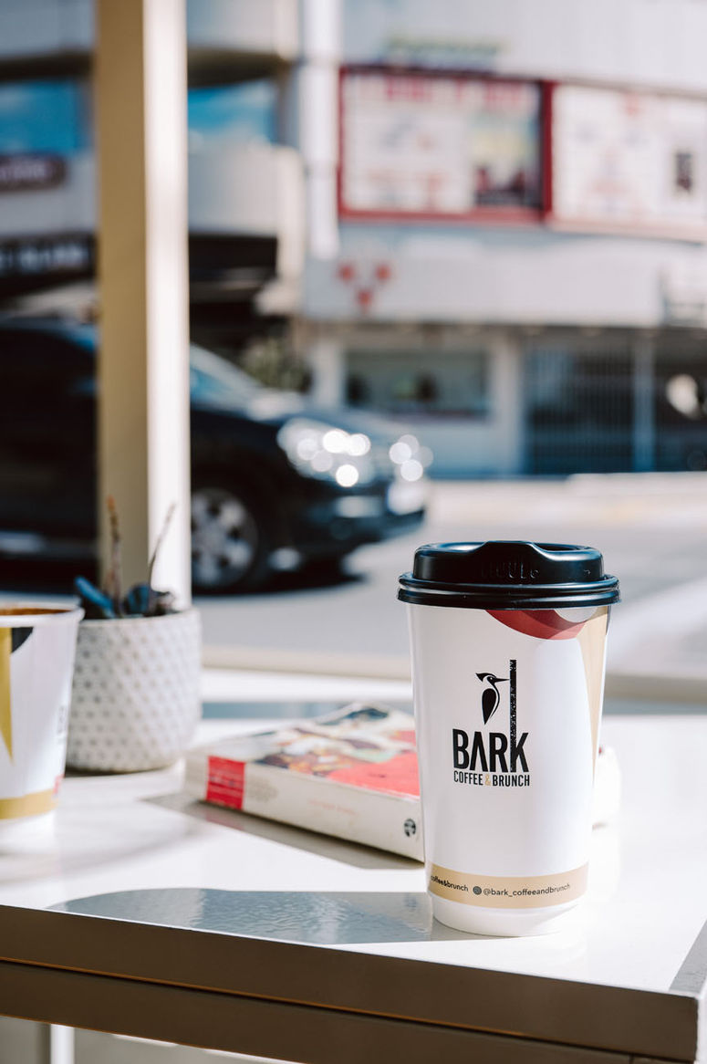 Styled takeaway cups photographed for coffee shop brand identity