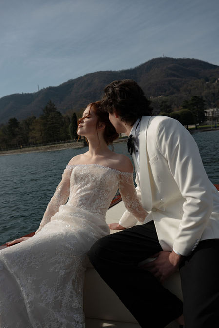 Romantic Lake Como destination wedding couple portraits on private boat ride with mountain views and morning natural light