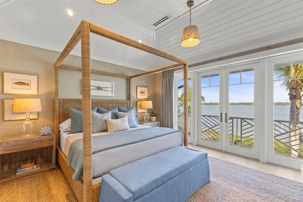 Luxury estate at dusk with glowing interior lights and waterfront backdrop