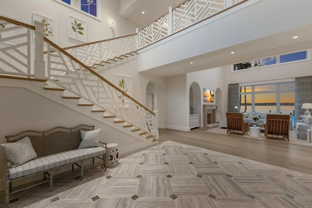 Luxury estate at dusk with glowing interior lights and waterfront backdrop