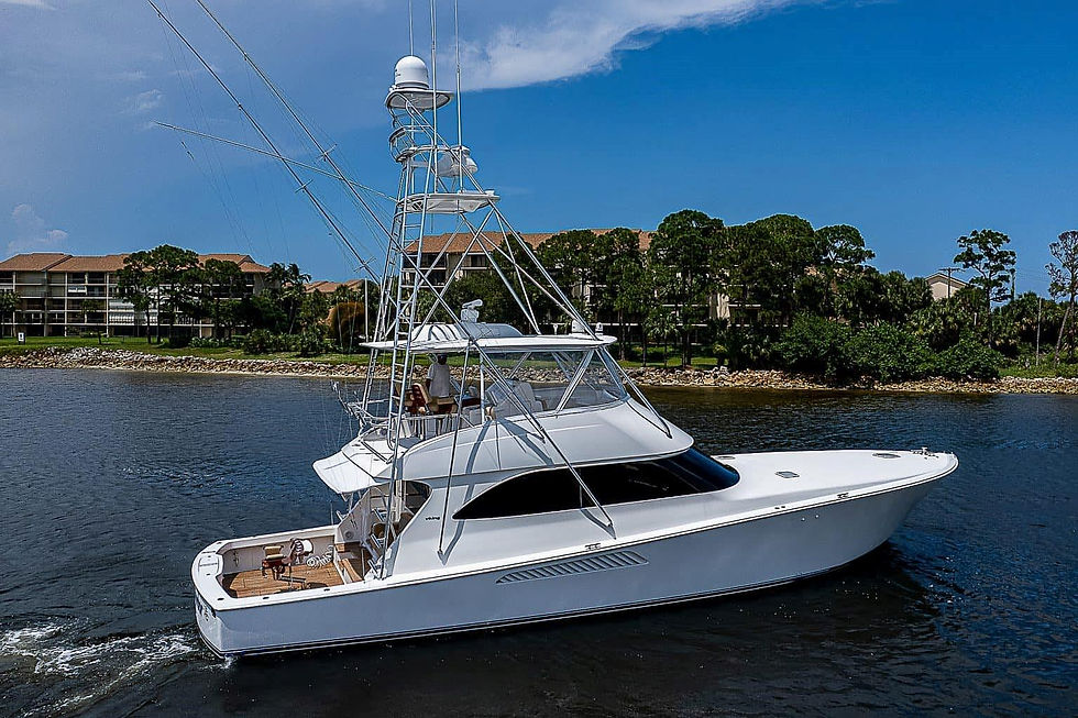 Why a Slow Boat Market Is Actually Good News for Smart Buyers. A white yacht sails on a calm waterway by lush green trees and buildings under a clear blue sky. The yacht has multiple decks and antennas.