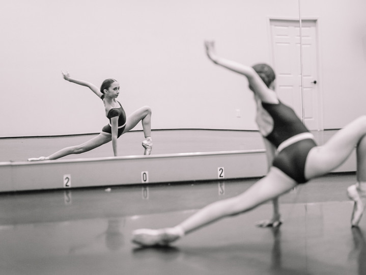 black & white image of girl in a ballet pose
