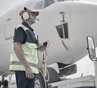 side-view-serious-airport-worker-sunglasses-headphones-staring-into-distance_447912-2928-(
