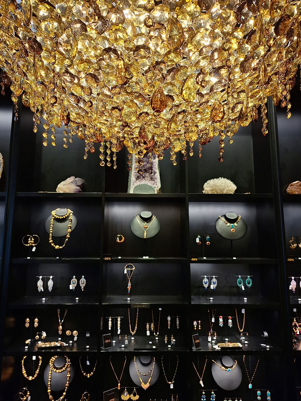 lampadario in cristallo colorato con composizione colore gold esposto in un negozio di gioielli a Milano