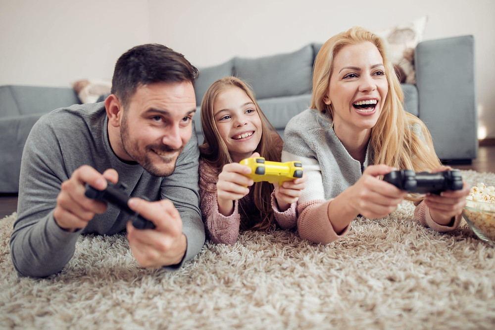 Two young parents play video game with daughter