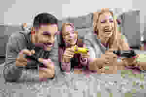 Two young parents play video game with daughter