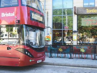 Public-access defibrillator outside Turtle Bay on Broad Quay in Bristol, shown beside a passing First Bus.