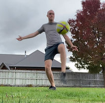 Alex Nelson kicks a football in mid-air
