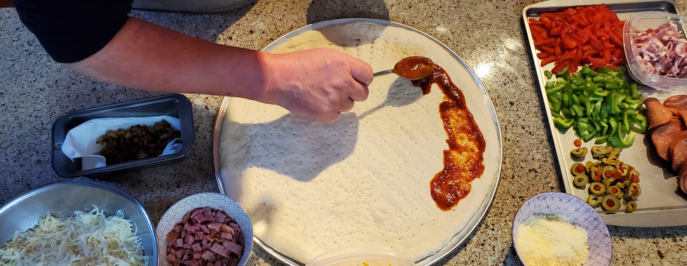 Start by spreading sauce around the outer edge.