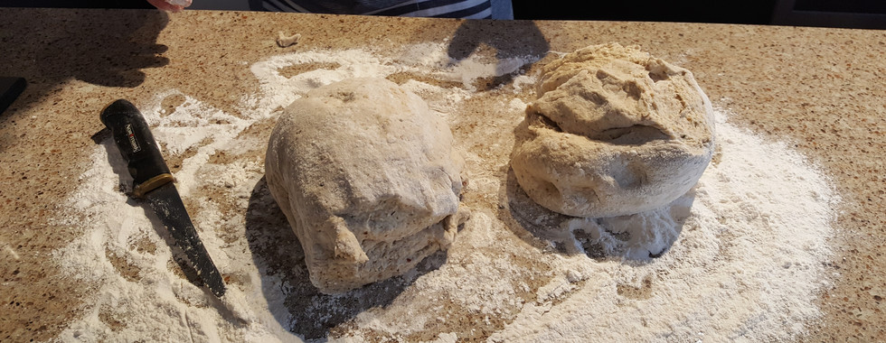 Two dough balls on a floured countertop