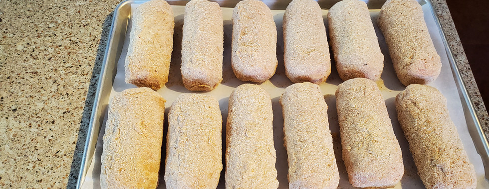 Lay breaded Chicken Cordon Bleu on a cookie tray.