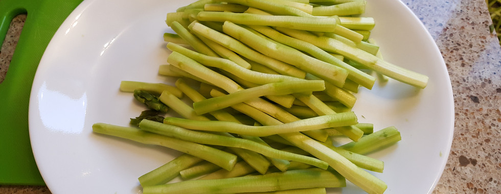 Peeled asparagus stems on a white plate