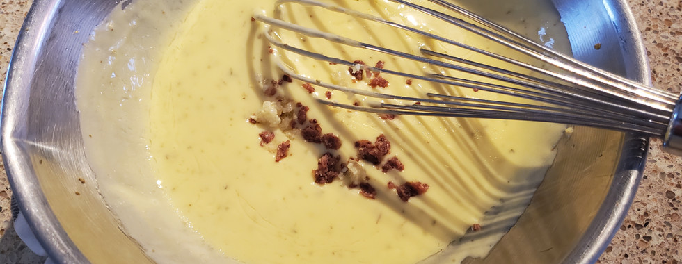 Adding chopped garlic and anchovies to Caesar dressing