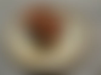 A piece of chocolate cake topped with chocolate icing on a beautiful plate.