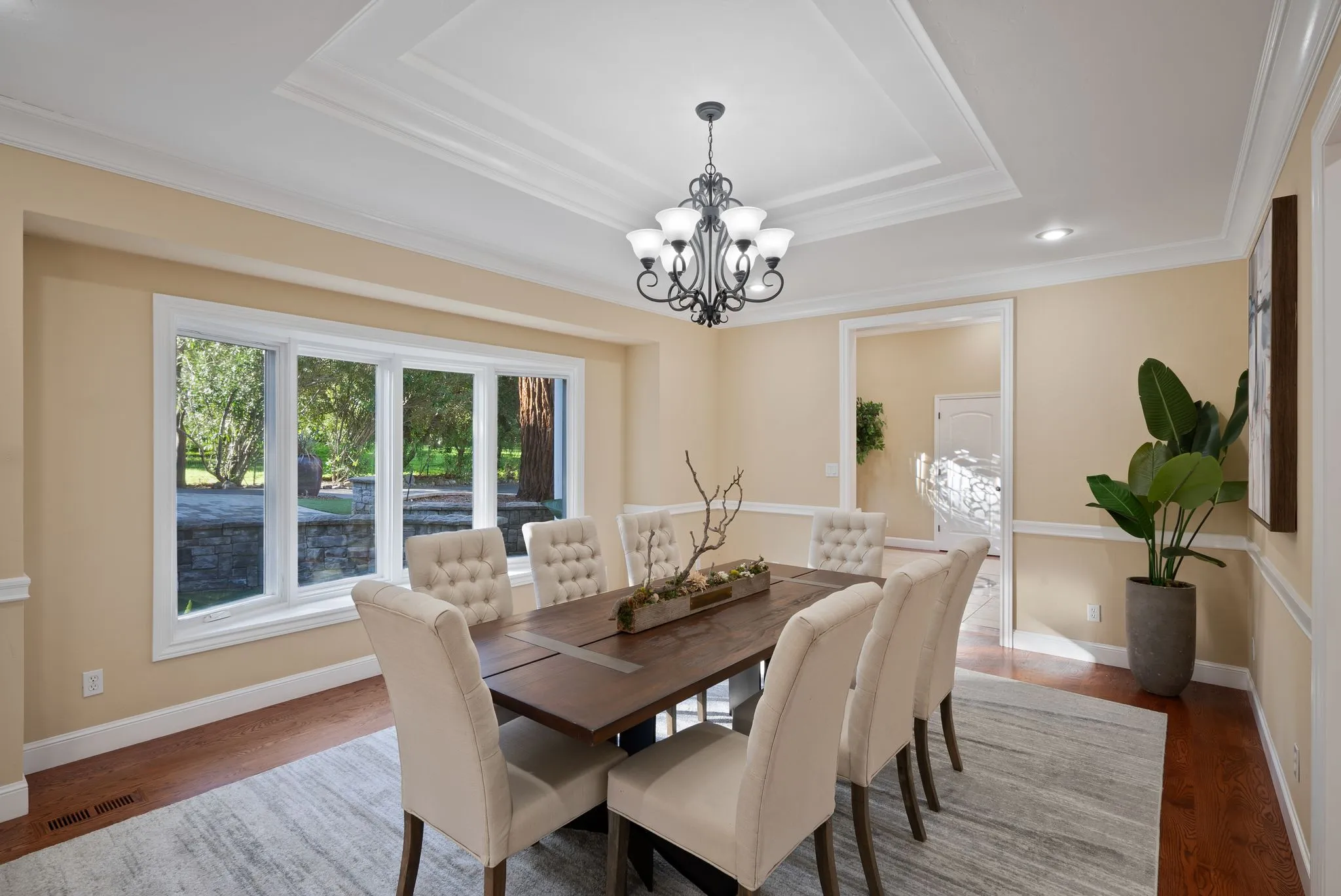 Updated dining room with large window, chandelier, and neutral decor from a dining room renovation project.
