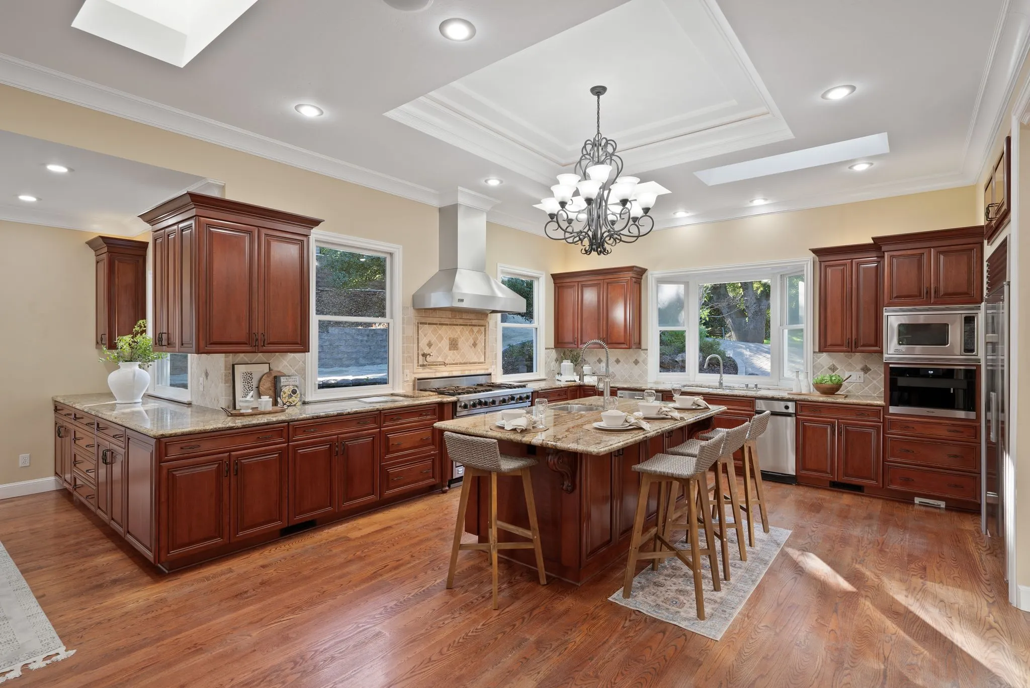 Upgraded kitchen with cherry wood cabinets, granite island, and modern lighting from a kitchen remodeling project in Concord, CA.