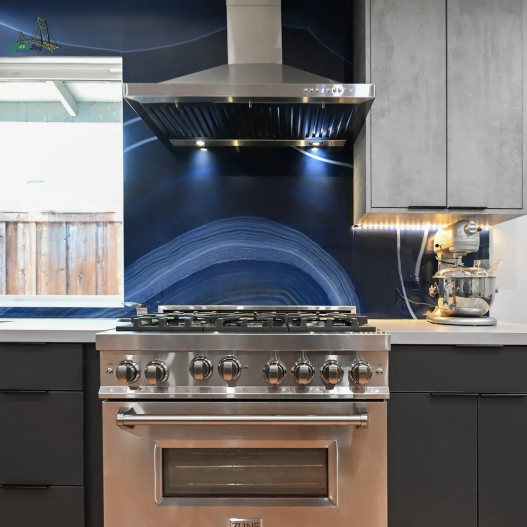 Bold kitchen design featuring a deep blue backsplash with agate pattern behind a stainless steel range and modern cabinetry.