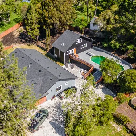 Aerial view of a home showcasing GBR Roofing’s roofing project, surrounded by greenery.