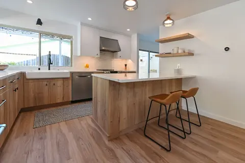 Contemporary kitchen with warm wood cabinets, quartz countertops, farmhouse sink, and open shelves – Green Bay Remodeling
