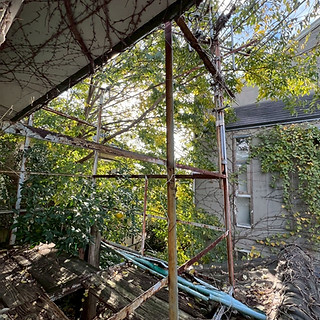 神戸市事例:蔦がはびこり、劣化により床が抜けたバルコニー