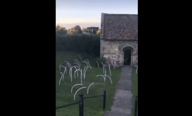 video of a chapel in the evening light surrounded by long thin tendril-like baloons moving in the breeze