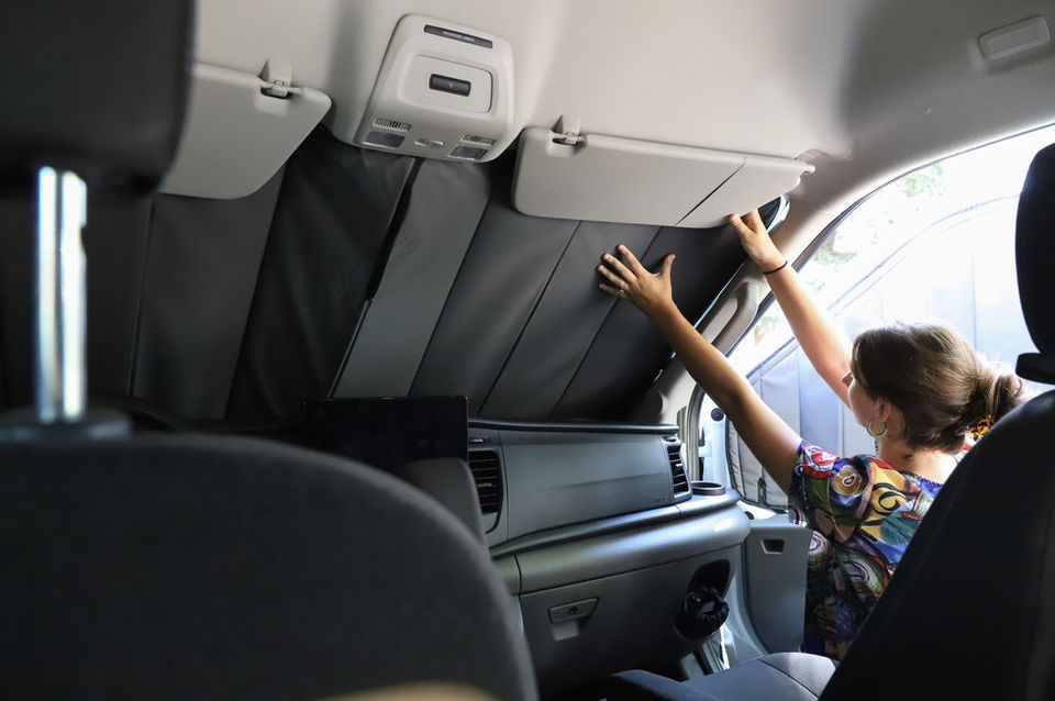 Woman installing van window shades for sun protection