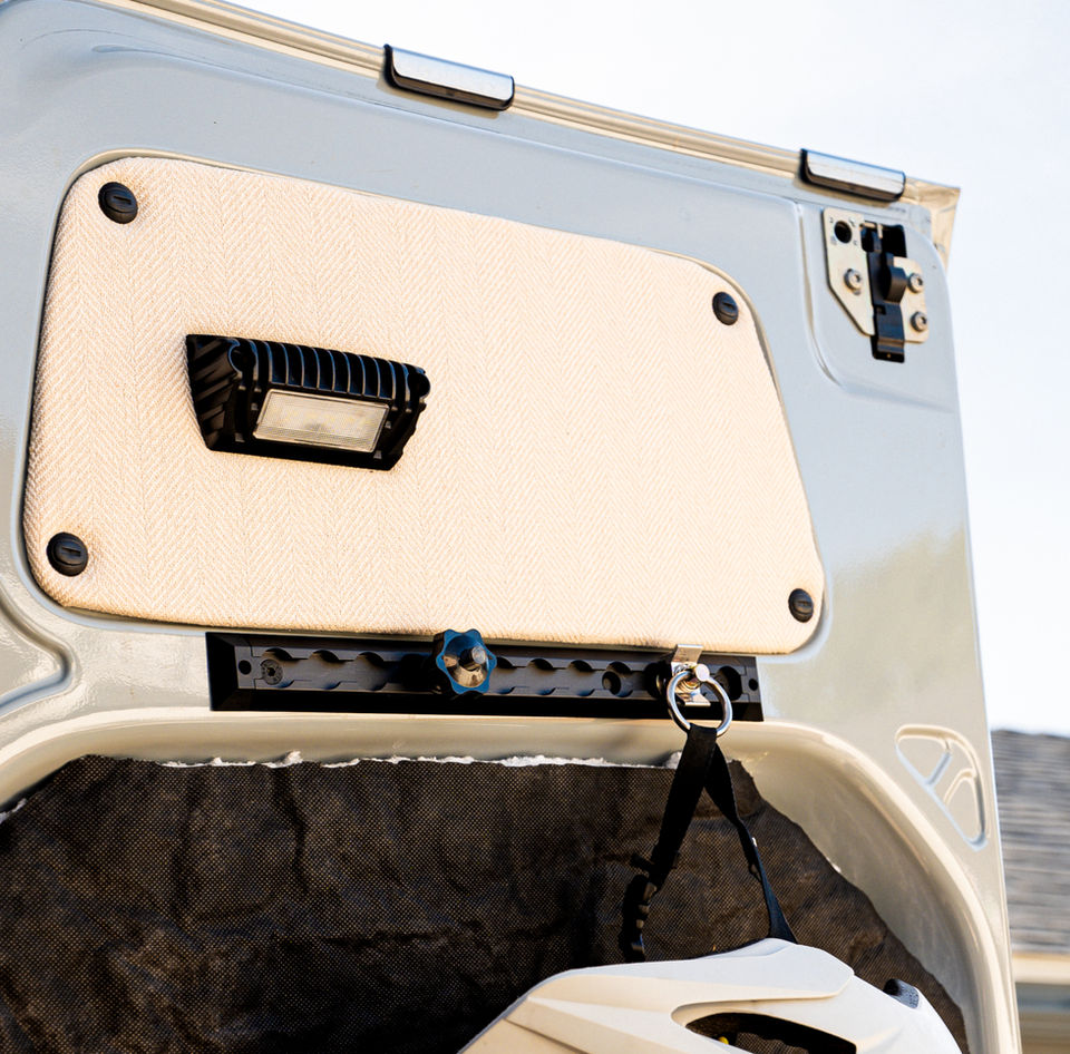 Truck tailgate with light, tie-down, and helmet