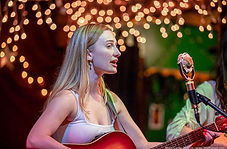 Cailin playing guitar and singing at Rapunzel's, for an open mic night.