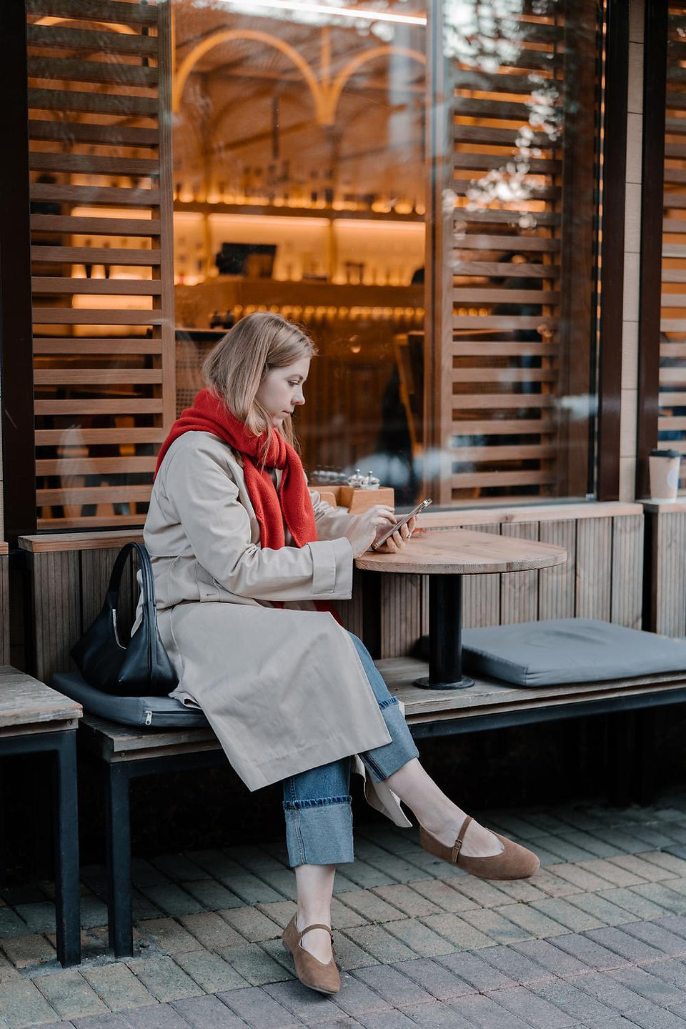 girl outside sitting at table on iphone