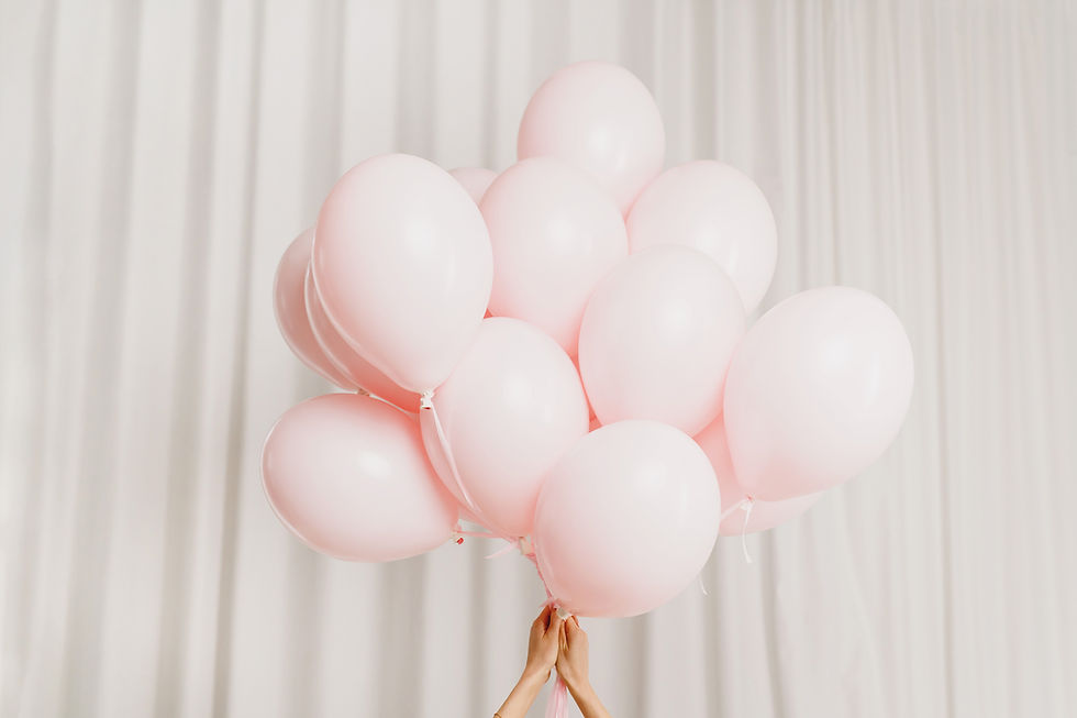 hand holding a bunch of pink balloons