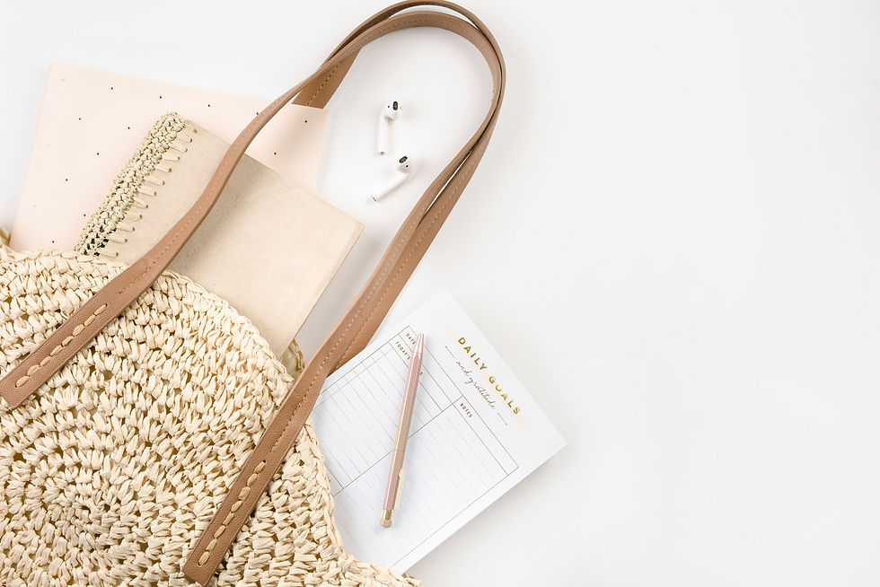 tote bag holding journal and ear buds