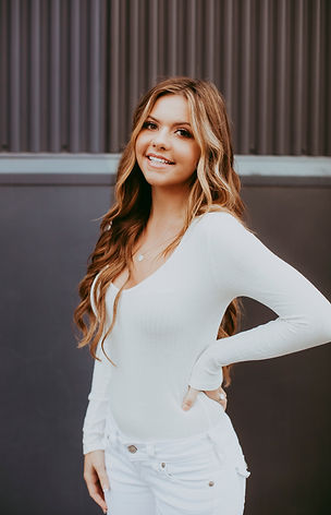 girl wearing white with hand on hip