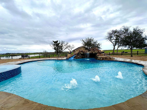 Residential Pool with aqua blue water, a stone slide, and a water feature