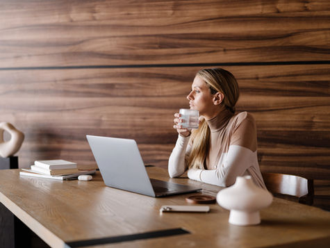 contemplative business woman holding drinking glass