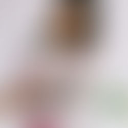 Hand holds phone photographing a woman with flowers in a bright white studio; screen shows PHOTO PORTRAIT PANO.