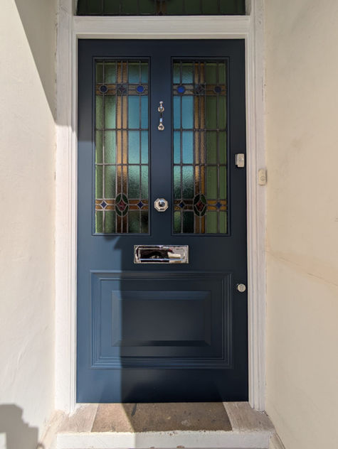 Authentic Victorian front door with a rich blue paint finish and detailed carvings.
