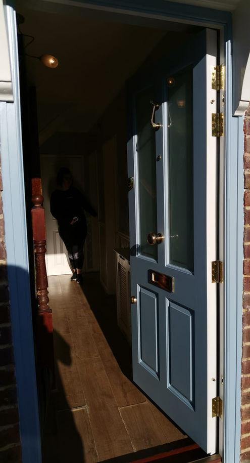 A classic Victorian front door adorned with etched glass panels and a polished chrome handle, reflecting timeless elegance.