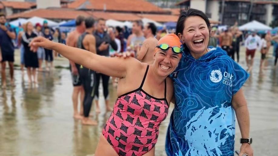 Open water swim coaches Sidney Russell and Angela Lee celebrate after swimming together on a team in the La Jolla Cove 10-Mile Relay.