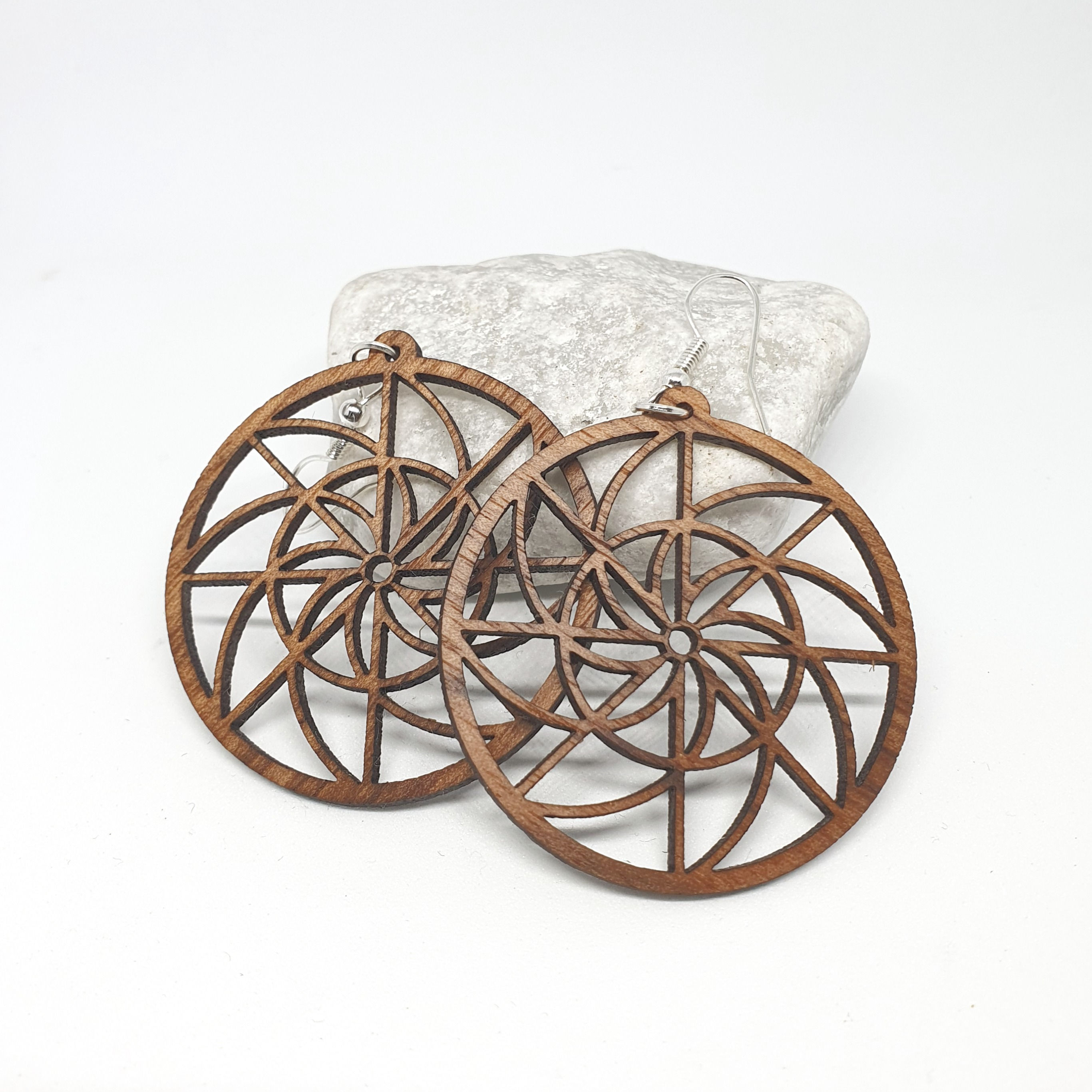 Boucles d'oreilles en bois de noyer, moyennes et rondes, avec un motif de mandala géométrique.