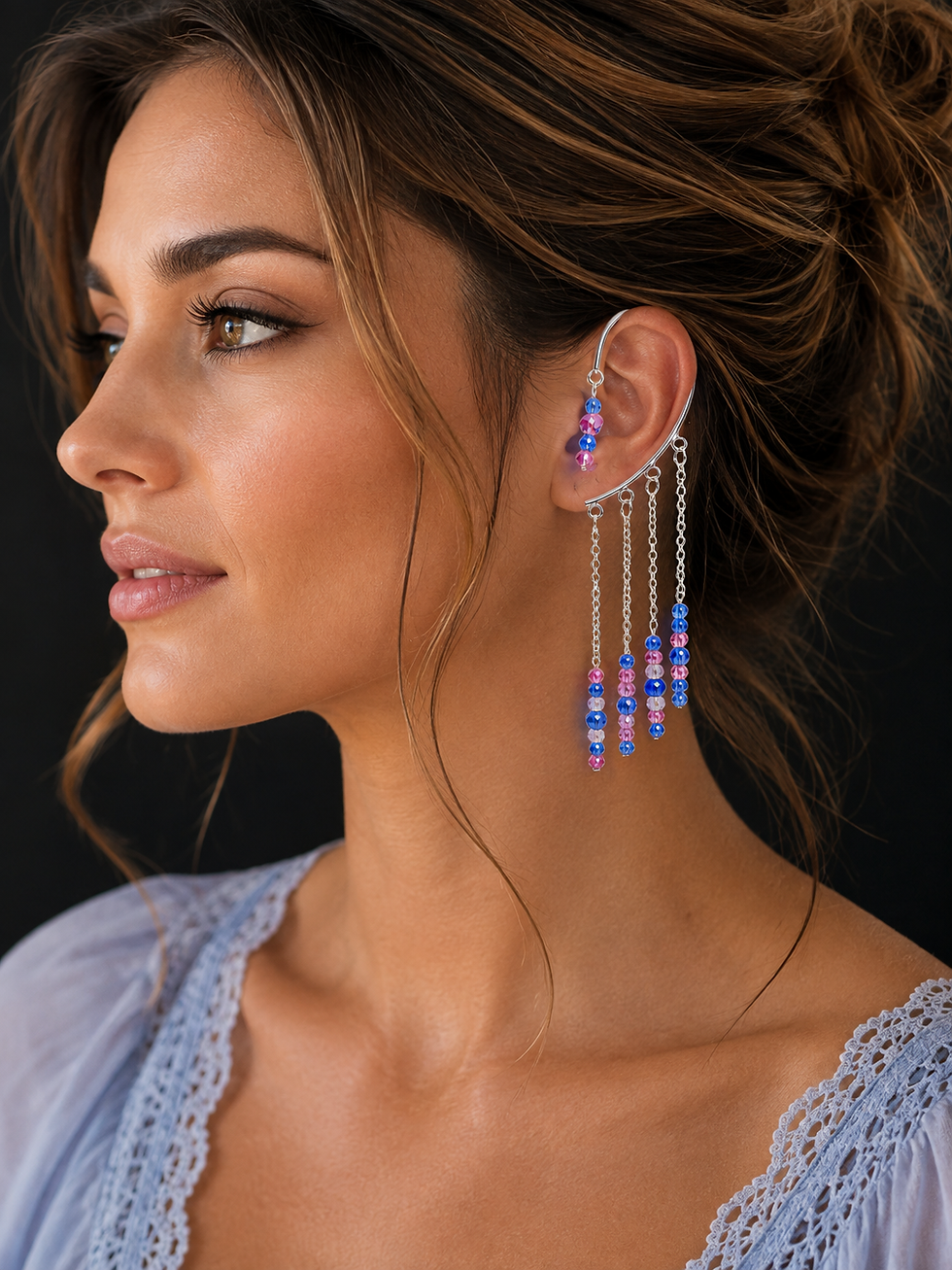 Woman wearing a silver ear cuff with cascading chains and sparkling pink, blue and iridescent crystal beads.
