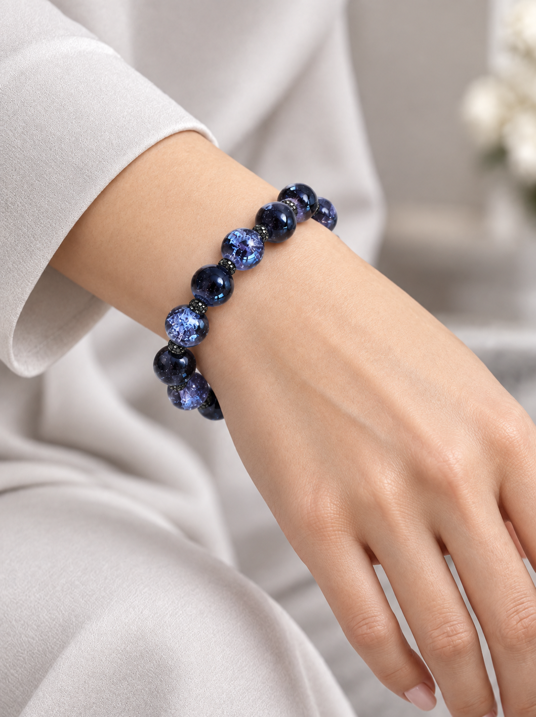 woman wearing a bracelet made of lavender crackle glass and black sparkly spacers