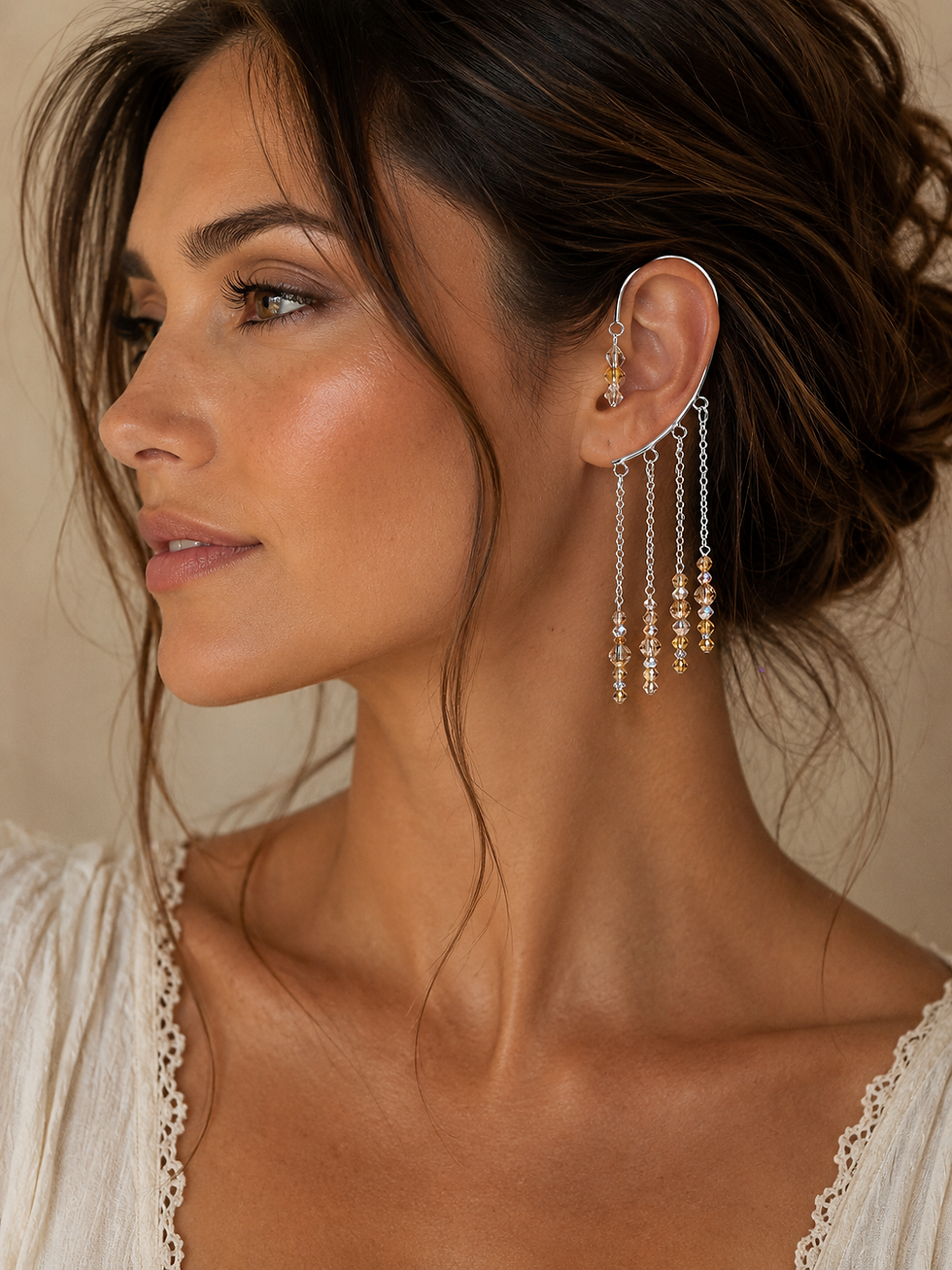 Silver cuff with silver and gold crystals hanging down on 4 chains behind the ear and a gold and silver charm in front