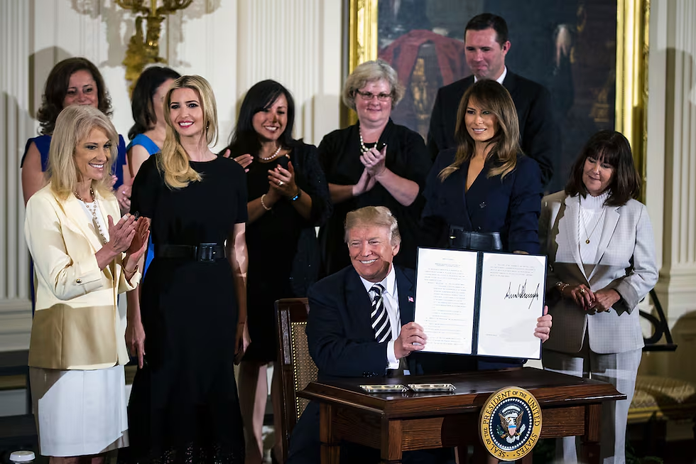 President Donald Trump holds up a signed executive order supporting military spouse employment on Wednesday, May 9, 2018. (Al Drago/Bloomberg via Getty Images)